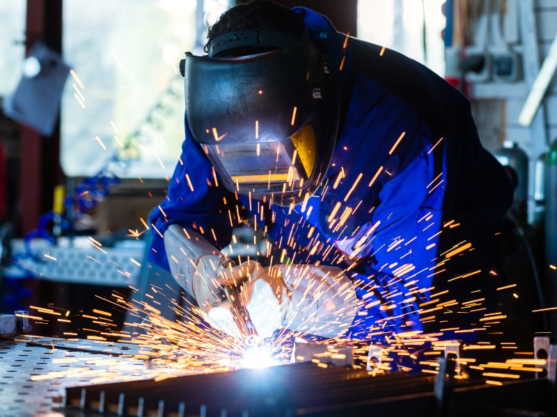 A skilled worker welds a piece of metal.